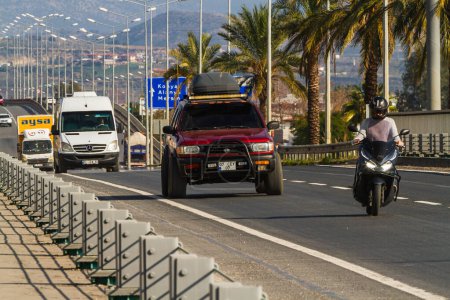 Téléchargez les photos : Côté, Turquie -22 janvier 2023 : Nissan Terrano rouge roule vite dans la rue par une chaude journée d'été sur fond de paumes - en image libre de droit
