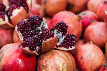 Photo for Close-up of bright fruits for background, texture. Red ripe pomegranates on display. - Royalty Free Image