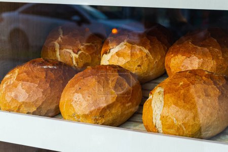 Foto de El primer plano del pan blanco fresco en rollos se encuentra en hileras pares en una panadería - Imagen libre de derechos