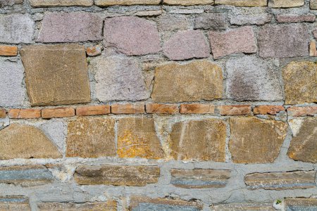 Foto de Fondo de pared con textura de piedras cortadas insertadas en mampostería de hormigón. la pared delante de la casa es decorativa - Imagen libre de derechos