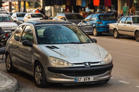 Foto de Side, Turkey -January 23, 2023: silver Peugeot 206 está estacionado en un cálido día de verano en el contexto de una calle - Imagen libre de derechos