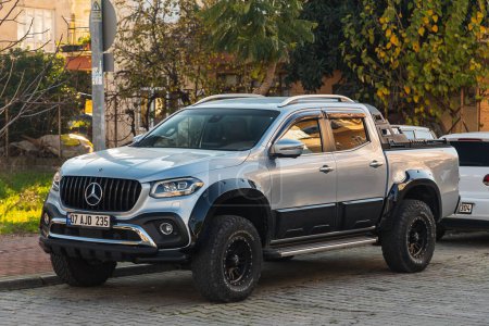 Téléchargez les photos : Side, Turkey -January 23, 2022:     silver Mercedes-Benz  X-Class   is parked  on the street on a warm summer day against the backdrop of a buildung, trees - en image libre de droit