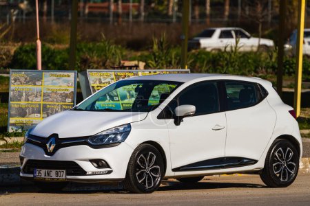 Photo for Side, Turkey  january 23 2023:    white Renault Clio  is parked  on the street on a warm summer day against the backdrop of a  street - Royalty Free Image