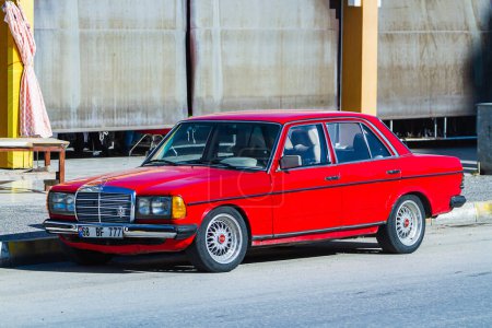 Photo for Side, Turkey -January 24, 2023:   red Mercedes-Benz  W123 , front view,   is  parking  on the street on a warm day against the backdrop of a building - Royalty Free Image
