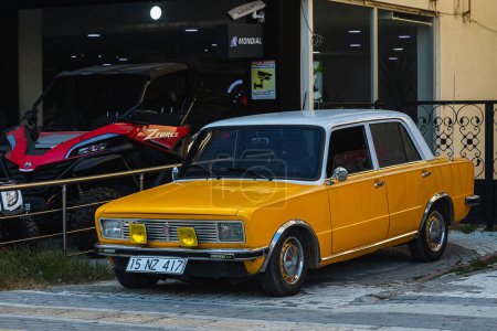 Foto de Side, Turkey -January 24, 2023: yellow Fiat 125, vista frontal, está aparcando en la calle en un día cálido con el telón de fondo de un edificio - Imagen libre de derechos