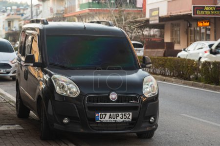 Foto de Side, Turkey -January 24, 2023: el Fiat Doblo negro está estacionado en la calle en un cálido día de verano - Imagen libre de derechos