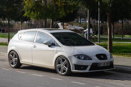Photo for Side, Turkey -January 27, 2023:   white Seat Leon  is parked  on the street on a warm summer day against the backdrop of a shops - Royalty Free Image