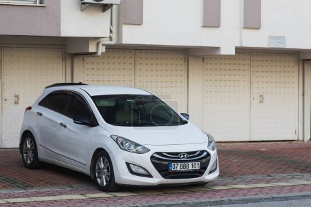 Foto de Side, Turkey -January 27, 2023:  white Hyundai I30  is parked  on the street on a warm day against the backdrop of a buildung,  shops - Imagen libre de derechos