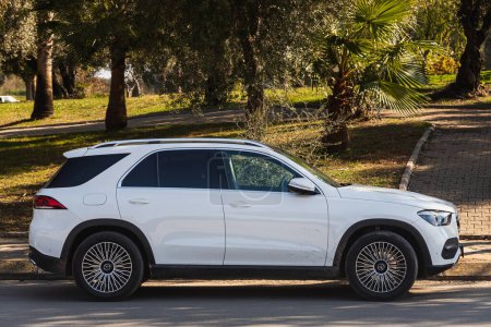 Photo for Side , Turkey -  January  27, 2023:    white Mercedes Benz GLE-class   is parked  on the street on a warm   day against the backdrop of a park - Royalty Free Image