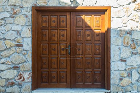 Photo for Close-up of a  brown wooden door in an old stone mansion house - Royalty Free Image