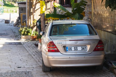 Foto de Side, Turkey -January 23, 2023:  silver  Mercedes-Benz C-class C200 is parked  on the street on a warm  day against the backdrop of a buildung, trees - Imagen libre de derechos