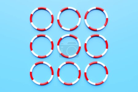 Téléchargez les photos : Bouées de sauvetage rouges et blanches sur fond bleu. Cercles multicolores en vol - en image libre de droit