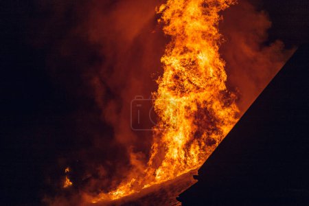 Photo for House on fire at night. Topics of arson and fires, disasters and extreme events. - Royalty Free Image