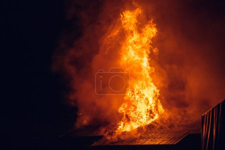 Foto de House on fire at night. Topics of arson and fires, disasters and extreme events. - Imagen libre de derechos