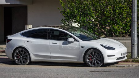 Foto de Side, Turkey -February 05, 2023: white Tesla Model 3 está aparcado en la calle en un día cálido - Imagen libre de derechos