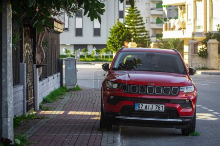 Photo for Side, Turkey -February 05, 2023:     red  Jeep Compass   is parked  on the street on a warm summer day against the backdrop of a  street, fence - Royalty Free Image