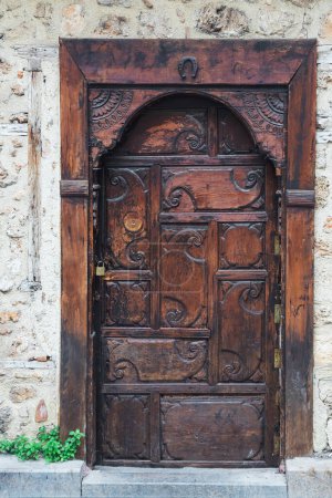 Téléchargez les photos : Gros plan d'une porte en bois brun dans une vieille maison de maître en pierre - en image libre de droit