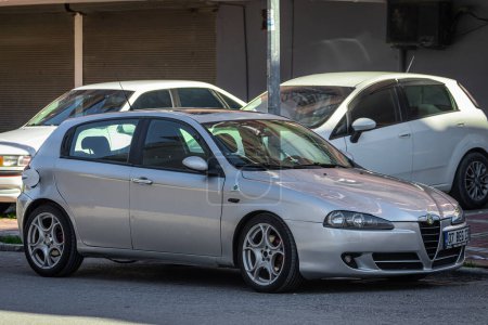 Photo for Side, Turkey  February 05 2023: white Alfa Romeo  147  is parked  on the street on a warm day - Royalty Free Image