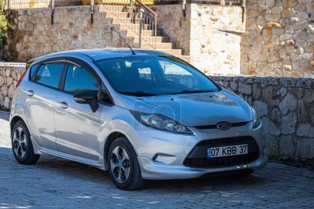 Photo for Side, Turkey - February 09, 2023:   silver Ford Fiesta   is parked  on the street on a warm day against the backdrop of a buildung,   park - Royalty Free Image