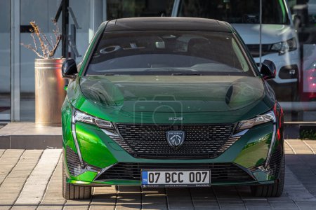 Foto de Lado; Turquía 18 de febrero de 2023: el nuevo Peugeot 308 verde está estacionado en la calle en un día cálido con el telón de fondo de un autosalón - Imagen libre de derechos