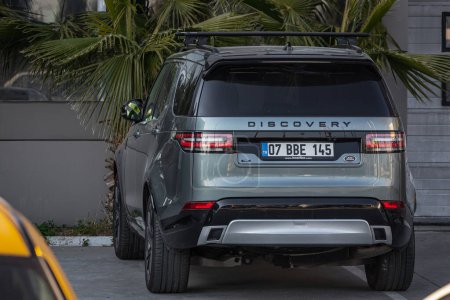Téléchargez les photos : Côté, Turquie - 18 février 2023 : Land Rover Discovery gris est stationné dans la rue par une chaude journée d'été sur fond d'autosalon - en image libre de droit