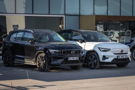 Photo for Antalya, Turkey - February 18, 2023:  New cars next to the car dealership.Black Volvo XC90 and  white Volvo XC40   is parked  on the street o n a warm   day against autosalon - Royalty Free Image