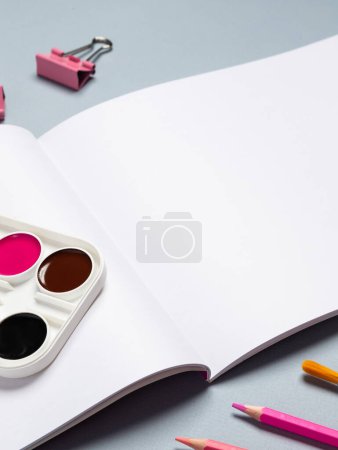 Photo for Open blank sheet of sketchbook with watercolors, gouache, brushes and other stationery on a light background, copy space - Royalty Free Image