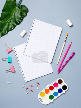 Foto de Diseño plano creativo maqueta de escritorio con cuaderno vacío, papelería sobre fondo azul - Imagen libre de derechos