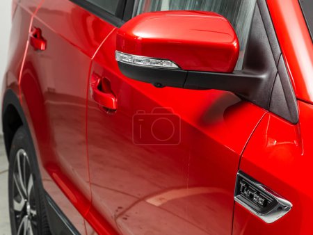 Téléchargez les photos : Miroir latéral d'une voiture rouge gros plan. Détail extérieur - en image libre de droit