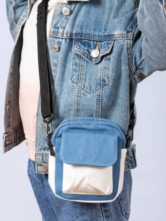 Photo for Close-up of a little girl in a denim jacket with a cute shoulder bag in the studio. - Royalty Free Image