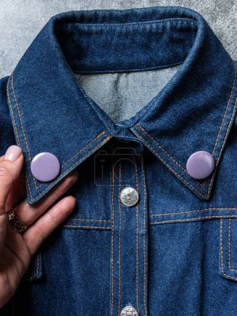 Téléchargez les photos : Badge rond gris bouton sur veste en denim. Insigne sur une veste vue rapprochée. Texture Contexte - en image libre de droit