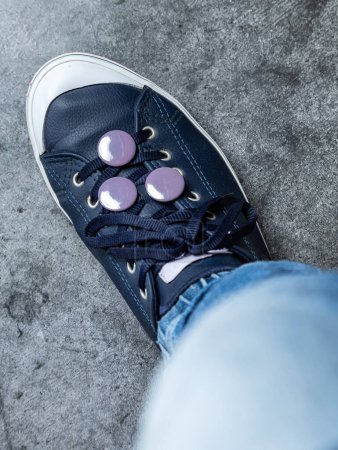 Foto de Botón redondo gris en la zapatilla de deporte. Icono del zapato de cerca. textura de fondo - Imagen libre de derechos