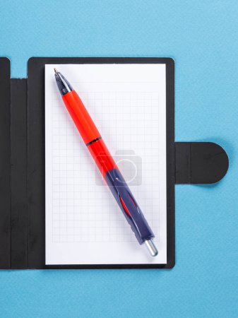Foto de Concepto de diseño - vista superior del bloc de notas con hojas blancas y lápiz sobre fondo azul para maqueta. - Imagen libre de derechos