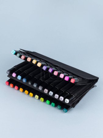 Foto de Un conjunto de marcadores profesionales en una caja negra sobre un fondo claro. Los marcadores para dibujar son muchos colores. - Imagen libre de derechos