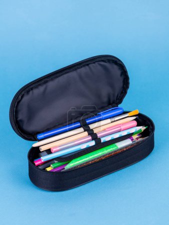 Foto de De vuelta al concepto escolar. Caja de lápiz con papelería escolar sobre fondo azul. - Imagen libre de derechos