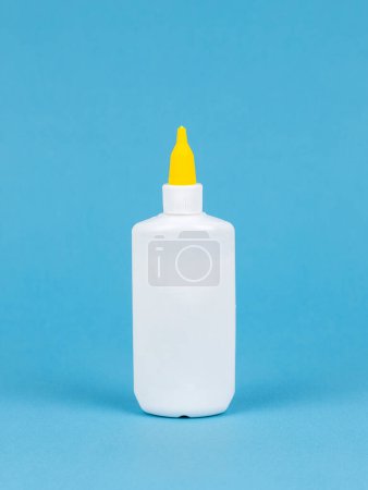 Foto de Botella de pegamento aislada sobre fondo azul, Primer plano - Imagen libre de derechos