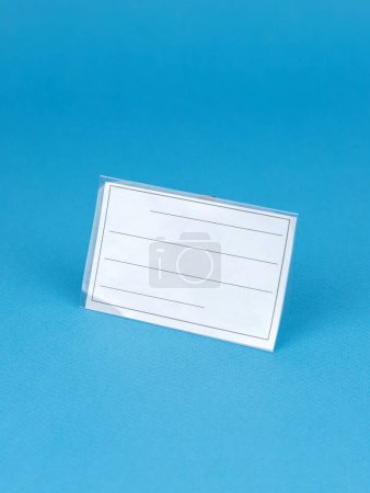Foto de Placa de plástico blanco en blanco sobre fondo azul. Plantilla de diseño sensible. Simulación para su diseño - Imagen libre de derechos