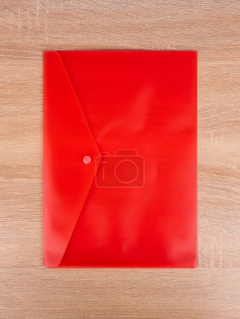 Foto de Carpeta de plástico rojo, sobre para documentos aislados sobre fondo azul - Imagen libre de derechos