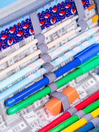Téléchargez les photos : Gros plan des stylos, crayons et feutres attachés dans un étui à crayons d'école - en image libre de droit