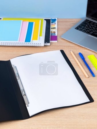 Photo for Open black plastic file folder with blank paper sheet isolated on blue, close up - Royalty Free Image