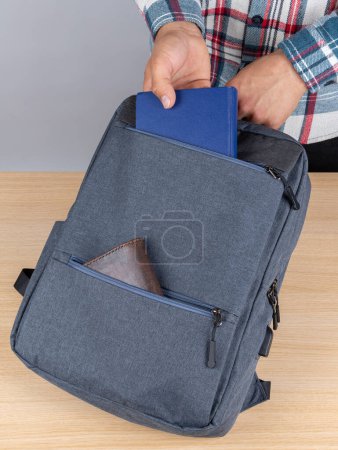 Photo for Close-up of a young male student taking out a book,notebook  from a backpack. - Royalty Free Image