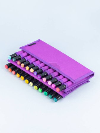 Foto de Un conjunto de marcadores profesionales en una caja púrpura sobre un fondo claro. Los marcadores para dibujar son muchos colores. - Imagen libre de derechos