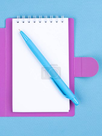 Photo for Design concept - top view of notepad with white sheets, bookmarks, binder and pen on blue background for mockup - Royalty Free Image