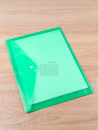 Foto de Carpeta de documento de plástico verde en mesa de madera - Imagen libre de derechos