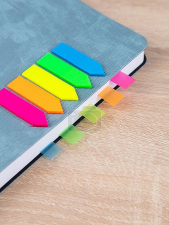 Photo for Close-up of multi-colored bookmarks in a gray notepad - Royalty Free Image