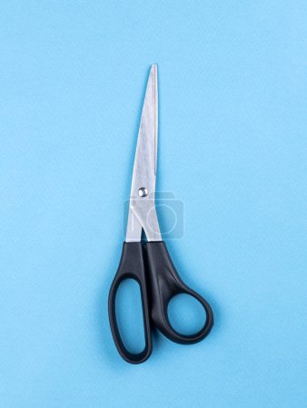 Téléchargez les photos : Les ciseaux sont des outils de coupe à main. L'objet est isolé sur un fond bleu sans ombres. - en image libre de droit