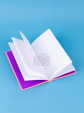 Foto de Cuaderno abierto vacío sobre un fondo azul, de cerca. Concepto de diseño - Imagen libre de derechos
