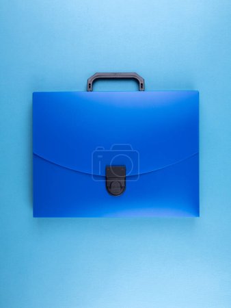 Téléchargez les photos : Porte-documents en plastique bleu pour documents et articles scolaires sur une table bleu vif - en image libre de droit
