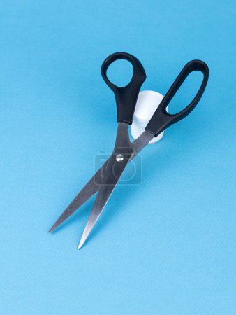 Photo for Scissors are hand-operated cutting tools. The object is isolated on a blue  background without shadows. - Royalty Free Image