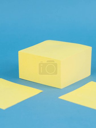 Foto de Hojas de papel adhesivo en blanco amarillo, aisladas sobre fondo azul - Imagen libre de derechos